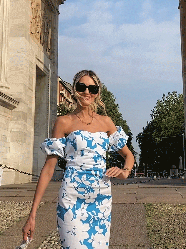 kobieta o blond włosach w kwiatowej stylizacji i ciemnych okularach w miejskiej przestrzeni