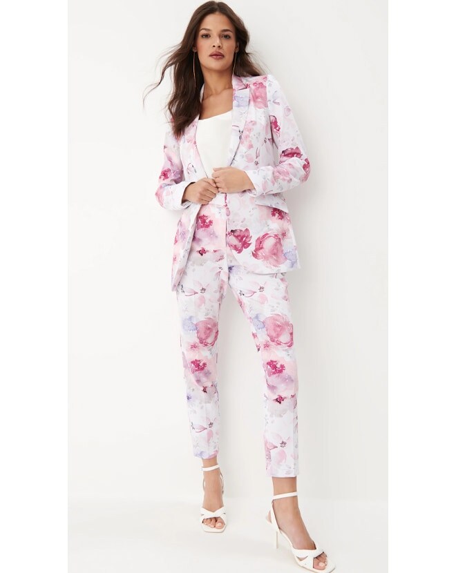 model într-un costum floral și sandale albe cu toc înalt