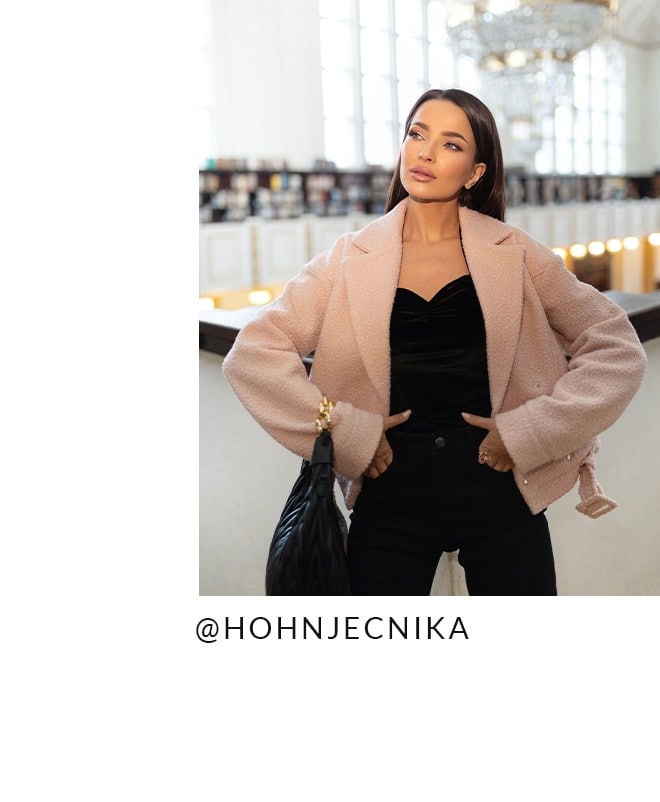 modelka w różowej kurtce, czarnym topie i spodniach skinny