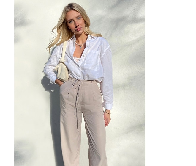 model într-o cămașă albă și pantaloni largi
