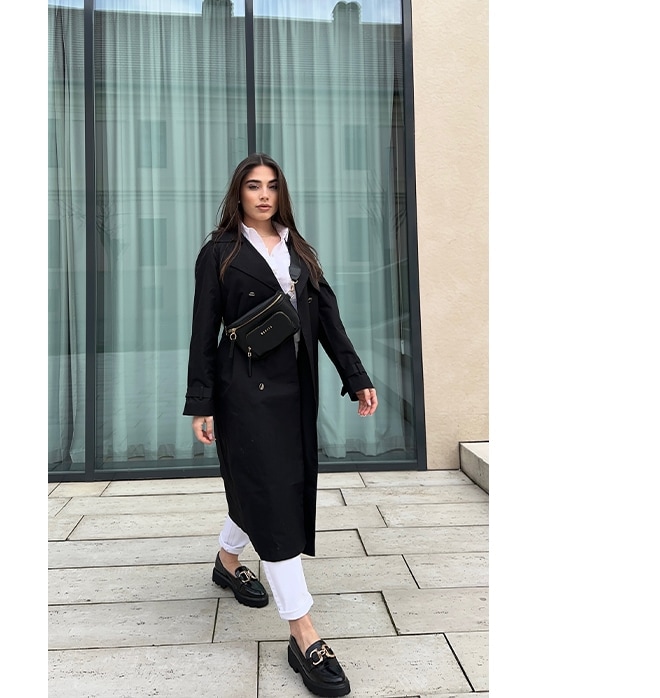 stil clasic - o femeie într-un trenci negru, mocasini și pantaloni albi