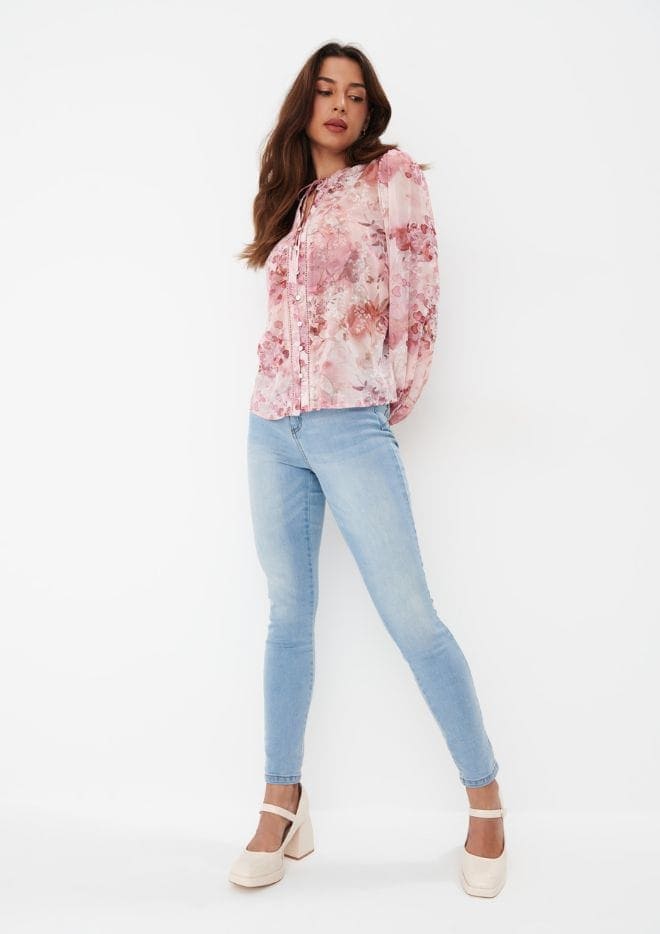 modelka w bluzce w kwiaty i jeansach skinny