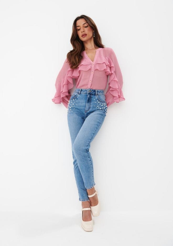modelka w różowej bluzce z falbanami i jeansach mom z ozdobnymi elementami
