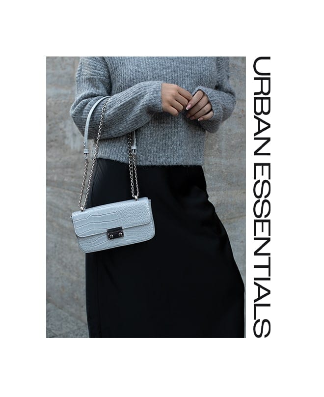 uită-te cu un pulover gri cu guler, o geantă gri și o fustă din satin- Stil urban