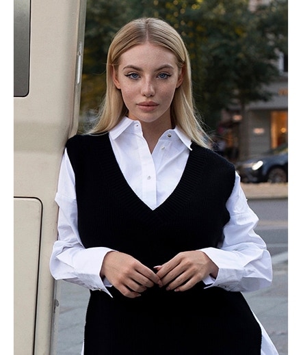 model într-o cămașă albă și vestă neagră