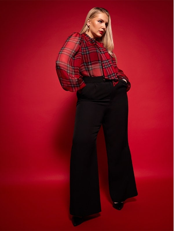 model într-o bluză în carouri și pantaloni largi