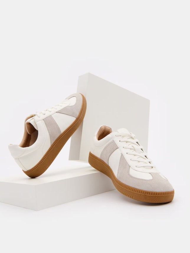Stylowe sneakersy z brązową podeszwą. Wykonane z materiału z dodatkiem skóry.