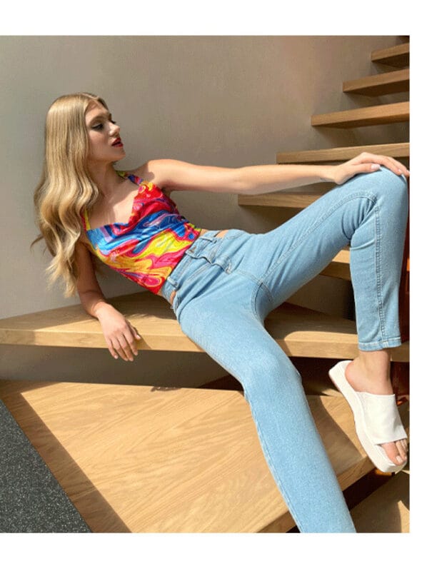 modne stylizacje 2022, modelka w koszulce na ramiączkach i jeansach