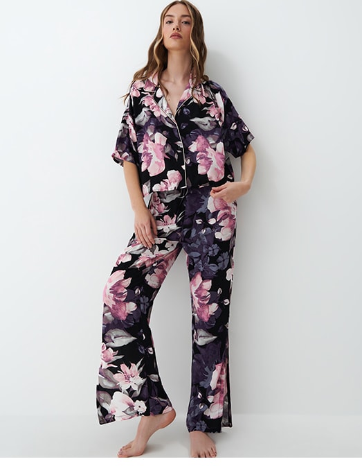 modelka w piżamie w kwiaty: koszula z zapięciem na guziki oraz długie spodnie 