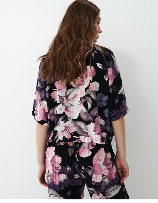 modelka prezentująca górę od piżamy w różowe kwiaty