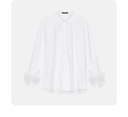 biała koszula z modowym akcentem w postaci piórek przy mankiecie