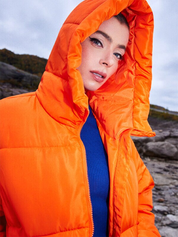 stylizacja z pomarańczową kurtką typu puffer i kobaltowym swetrem