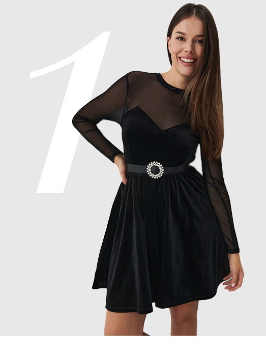 kobieta w welurowej czarnej sukience mini z ozdobnym paskiem - sukienka zimowa wyprzedaż 2023
