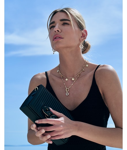 modelka w eleganckim looku - czarna torebka, modny naszyjnik i kolczyki