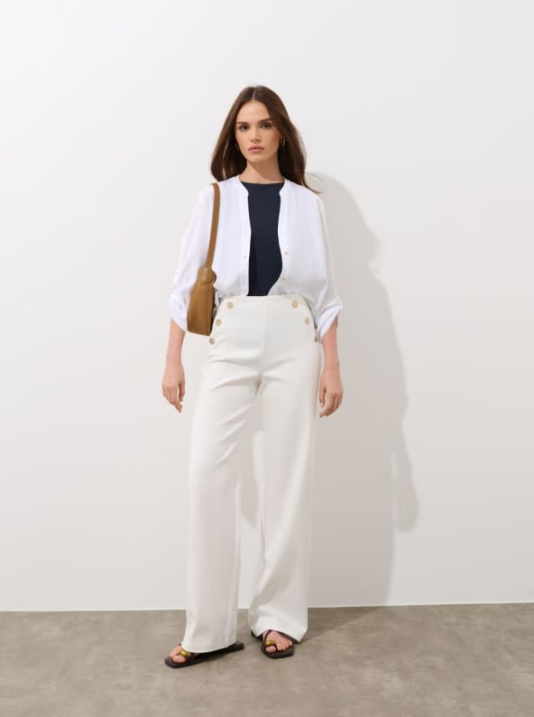 Spodnie z wysokim stanem i szeroką nogawką. Posiadają ozdobne guziki z przodu, uszyte w 75% z wiskozy.
