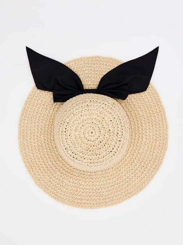 Kapelusz słomkowy z ozdobną kokardą.
