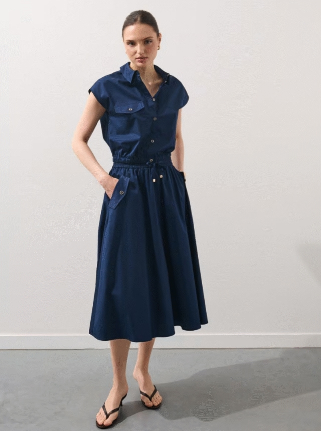 Bawełniana spódnica o kroju litery A i długości midi. Posiada wiązanie w pasie.
