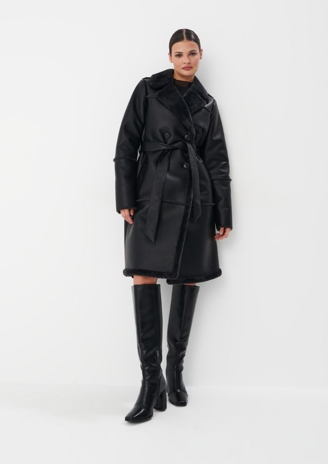 modelka w total black looku - czarny płaszcz z kożuchem i kozaki