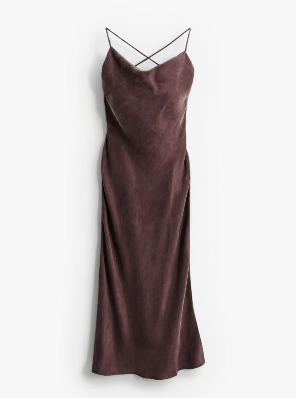 Sukienka w odcieniu czekoladowego brązu, o długości maxi. Posiada lejący dekolt. Uszyta z mieszanki cupro i wiskozy.
