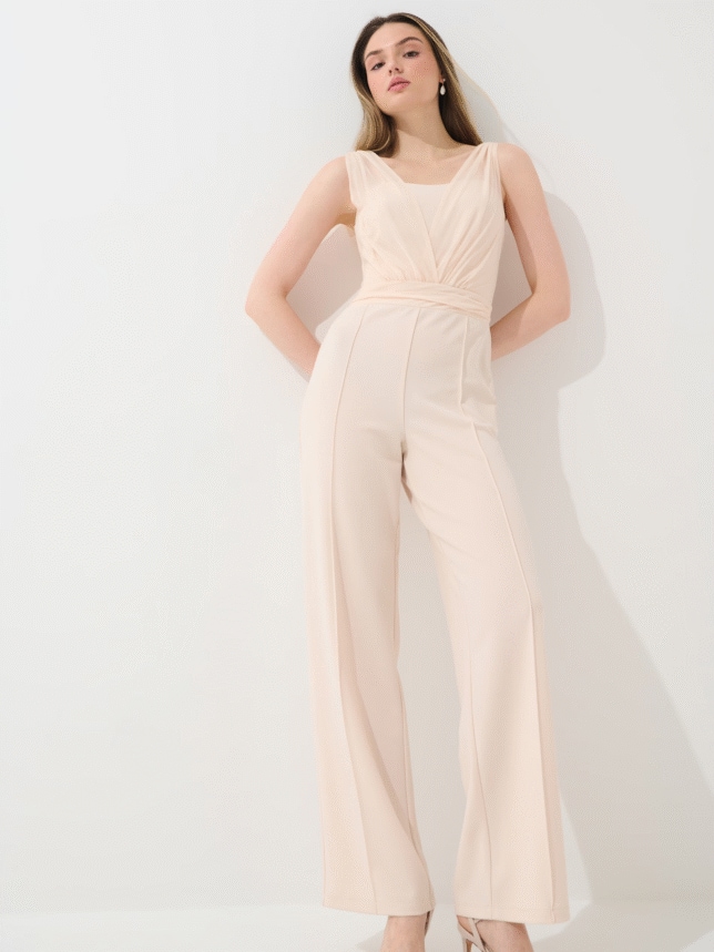 Modelka w stylizacji w kombinezonie damskim, elegancki outfit w beżowym kolorze