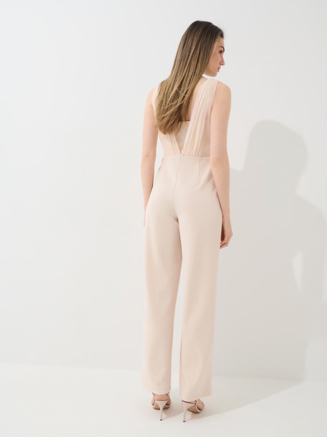 Kobieta w kombinezonie w kolorze beżowym, buty na obcasie