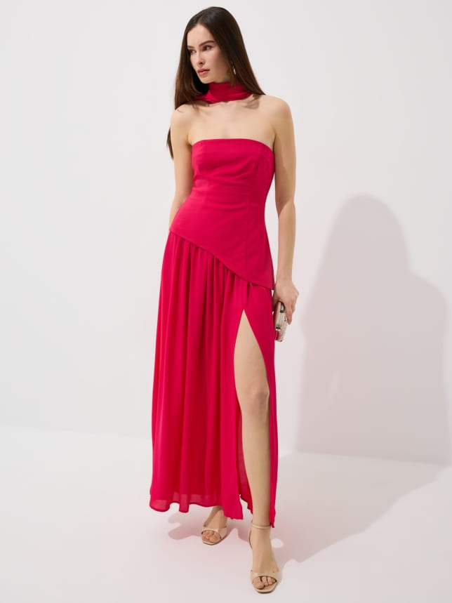 Sukienka o długości maxi z ozdobnym szalem na szyi i rozcięciem z przodu. Uszyta w 50% z bawełny.
