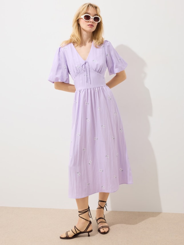 Fioletowa sukienka o kroju litery A i długości midi, z bufiastymi rękawami. Delikatna i subtelna, idealna na wesele.
