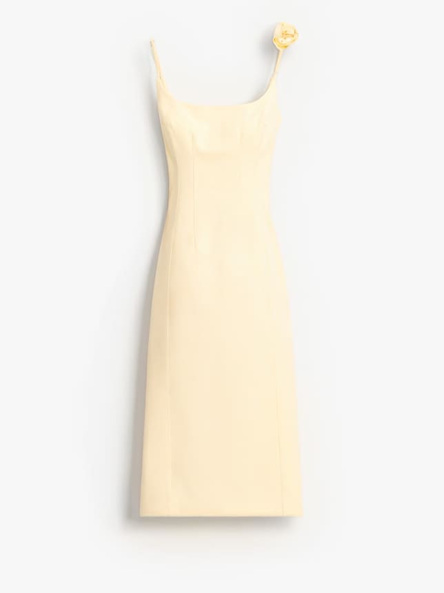 Masełkowa, piękna sukienka na wesele. Ołówkowa sukienka o długości midi na ramiączkach. Posiada ozdobny detal 3D w kształcie róży.
