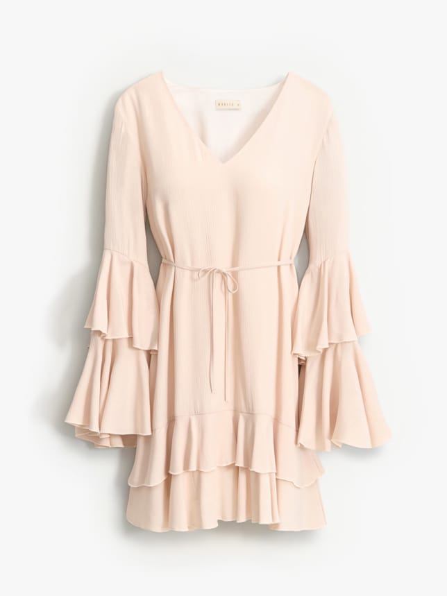 Sukienka o długości mini w stylu bohu. Posiada dekolt w kształcie V, wiązanie w talii i długie rękawy.
