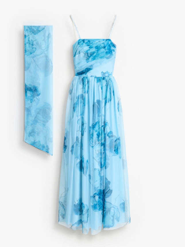 Elegancka sukienka na wesele w kolorze błękitnym z tiulowym, rozkloszowanym dołem i kwiatowym motywem. Model na cienkich ramiączkach z dopasowanym szalem, idealny dla gościa weselnego lub druhny.