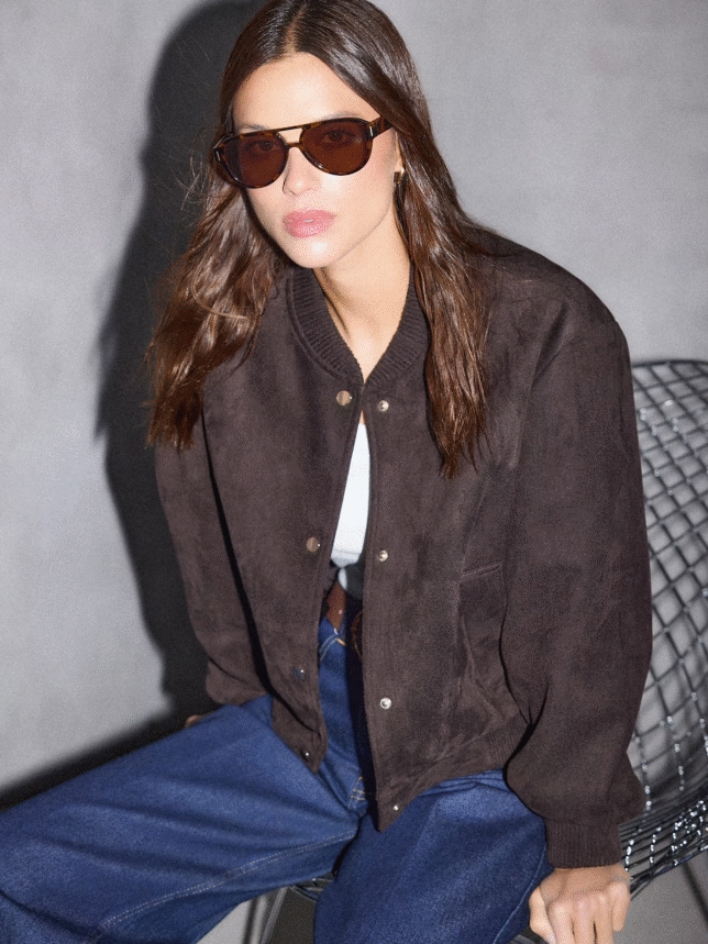 Modelka w stylizacji na wiosnę 2026 w jeansach, brązowej bomberce i okularach przeciwsłonecznych