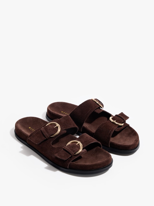 Skórzane klapki z odobnymi klamrami. O brązowej barwie.
