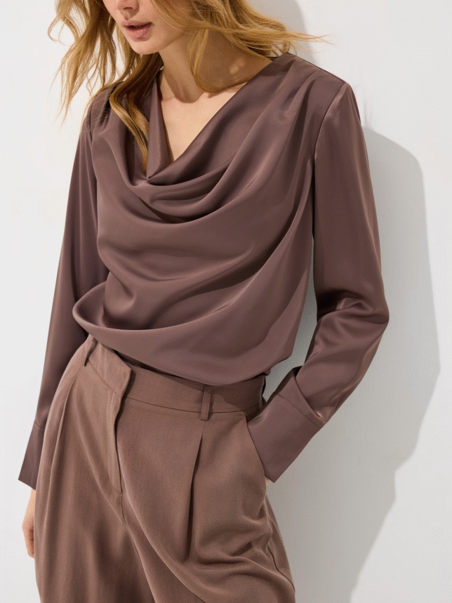 Zbliżenie na brązową bluzkę damską z dekoltem typu woda i szerokimi mankietam