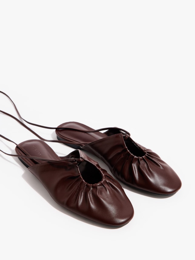 Klapki typu mule z wiązaniem i ozdobnym przodem.
